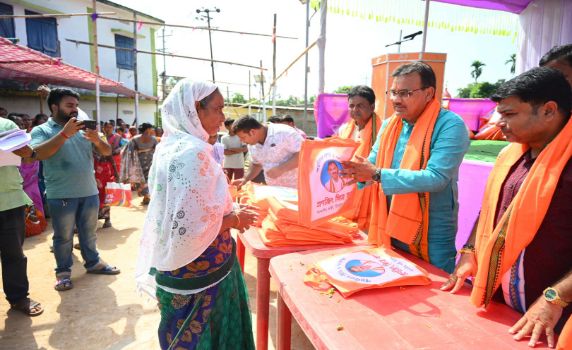 Tripura Finance minister Pranajit Singha Roy distributes puja gifts among women in Udaipur.
